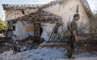 An Israeli soldier stands in front of a house hit by Hezbollah rockets in the deserted northern Israeli town of Metula on November 4, 2024. (Menahem KAHANA / AFP)