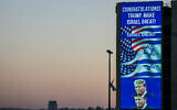 A large billboard congratulating US Republican presidential candidate and former president Donald Trump, is lit on the side of a building in Jerusalem on November 6, 2024. (Ahmad Gharabli/AFP)
