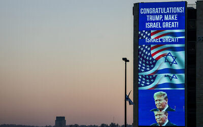 A large billboard congratulating US Republican presidential candidate and former president Donald Trump, is lit on the side of a building in Jerusalem on November 6, 2024. (Ahmad Gharabli/AFP)