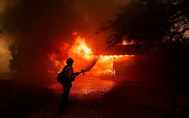 A firefighter tries to control the fire burning down a house as the Mountain Fire scorches acres, the wildfire fueled by strong Santa Ana winds, in Camarillo, California, on November 6, 2024. (ETIENNE LAURENT / AFP) A firefighter tries to control the fire burning down a house as the Mountain Fire scorches acres, the wildfire fueled by strong Santa Ana winds, in Camarillo, California, on November 6, 2024. (ETIENNE LAURENT / AFP)