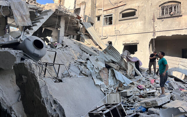 Palestinian men check the damage outside a building destroyed in an Israeli bombardment against Hamas in Beit Lahia in the northern Gaza Strip on November 7, 2024. (AFP)
