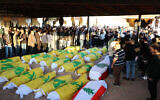 People attend the funeral of people wrapped in Hezbollah and Lebanon flags on November 12, 2024, in Haouch al-Rafqa in Lebanon's the Bekaa valley. (Nidal SOLH / AFP)