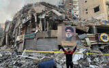 A man flashes a portrait of slain Hezbollah chief Hassan Nasrallah in front of the rubble of a building at the site of an Israeli airstrike in Beirut's southern suburbs, on November 12, 2024, amid the ongoing war between Israel and Hezbollah. (AFP)