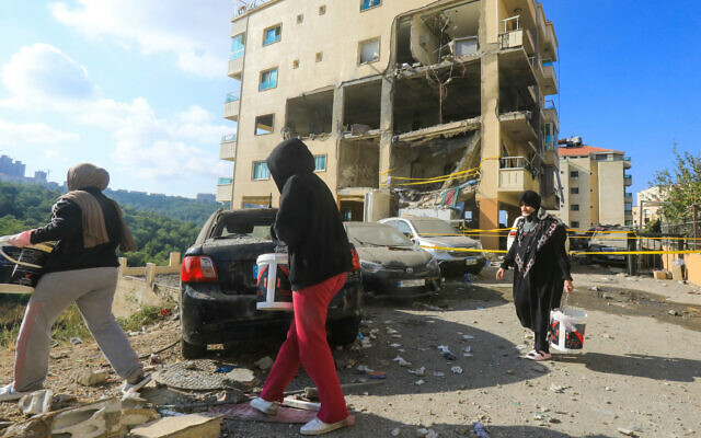 Residents walk past damaged cars in front of an apartment destroyed in an Israeli strike on Hezbollah in the Dawhet Aramoun area, south of Beirut, on November 13, 2024 (AFP) Residents walk past damaged cars in front of an apartment destroyed in an Israeli strike on Hezbollah in the Dawhet Aramoun area, south of Beirut, on November 13, 2024 (AFP)
