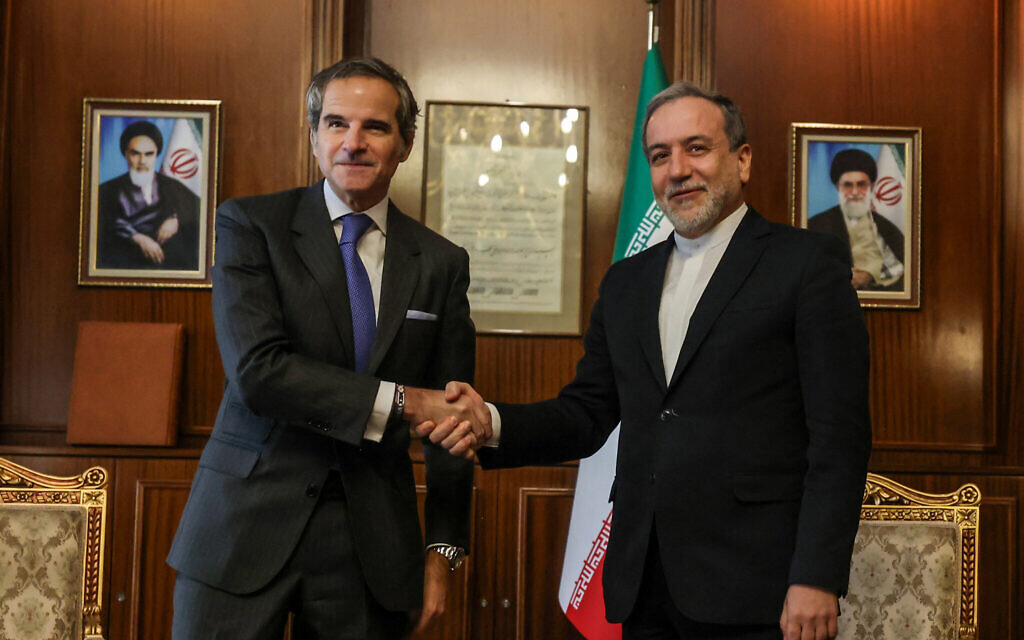 Iran's Foreign Minister Abbas Araghchi (R) shakes hands with International Atomic Energy Agency (IAEA) Director General Rafael Mariano Grossi before a meeting in Tehran on November 14, 2024. (Photo by Atta KENARE / AFP)