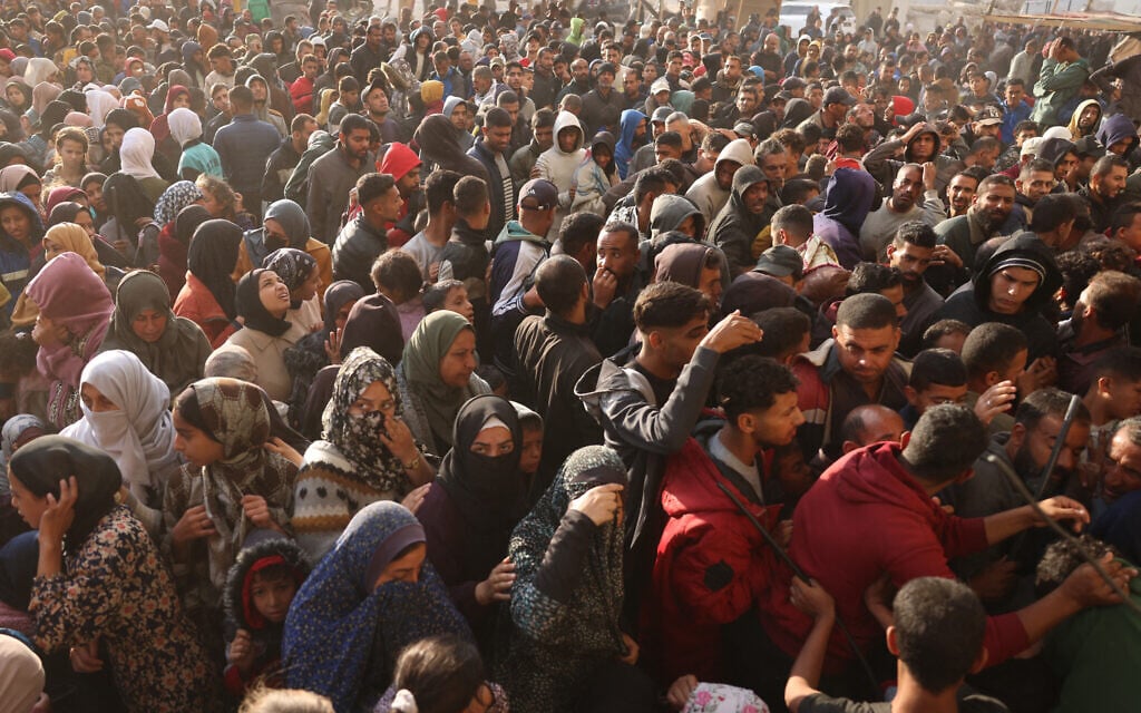 Palestinians wait in a queue to receive bread outside a bakery in Khan Yunis on November 18, 2024, amid the ongoing war between Israel and Hamas. (Photo by BASHAR TALEB / AFP)