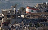 This picture taken from a position in northern Israel, near the border with Lebanon, shows an Israeli flag (L) on a destroyed building, and a Lebanese flag (R) painted on a damaged building in the southern Lebanese village of Meiss El-Jabal on November 25, 2024 (Photo by Jalaa MAREY / AFP)