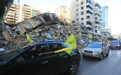 Motorists wave the flag of Hezbollah as they parade in Beirut's southern suburbs on November 27, 2024, after a ceasefire between Israel and Hezbollah took effect. (AFP)
