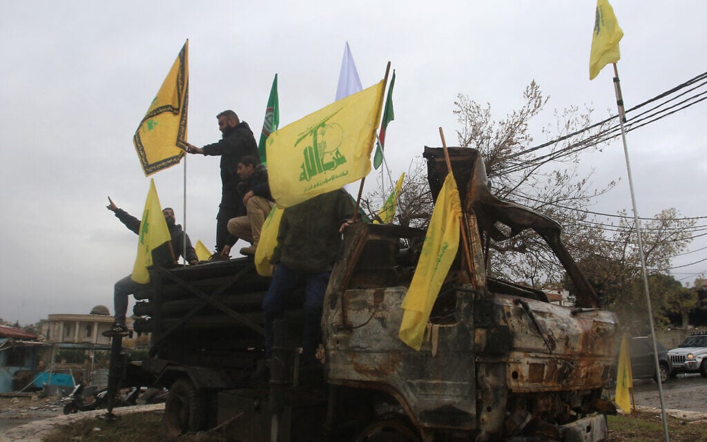 People pose for a picture on a burnt Hezbollah rocket launcher in the southern Lebanese village of Kafr Tibnit on November 27, 2024. (Mahmoud ZAYAT / AFP)