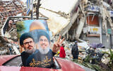 A driver holds up portraits of Hezbollah's slain leaders Hassan Nasrallah and Hashem Safieddine as people return to Beirut’s southern suburbs on November 27, 2024, after a ceasefire between Israel and Hezbollah took effect. (Ibrahim Amro/ AFP)