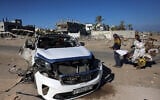 People check a car hit by an Israeli strike in Khan Younis in the southern Gaza Strip on November 30, 2024, in which five people were reported killed. (Bashar Taleb/AFP)