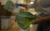 An election official sorts mail-in ballots at the Maricopa County Tabulation and Election Center in Phoenix, Arizona, March 5, 2024. (AP Photo/Serkan Gurbuz, File)