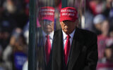 Republican presidential nominee former US president Donald Trump is reflected in the bullet proof glass as he finishes speaking at a campaign rally in Lititz, Pennsylvania, November 3, 2024. (AP Photo/Matt Rourke)