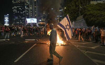 Israelis light a bonfire on a Tel Aviv highway during a protest after Prime Minister Benjamin Netanyahu dismissed Defense Minister Yoav Gallant on November 5, 2024. (AP/Oded Balilty)