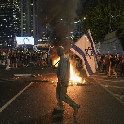 Israelis light a bonfire on a Tel Aviv highway during a protest after Prime Minister Benjamin Netanyahu dismissed Defense Minister Yoav Gallant on November 5, 2024. (AP/Oded Balilty)