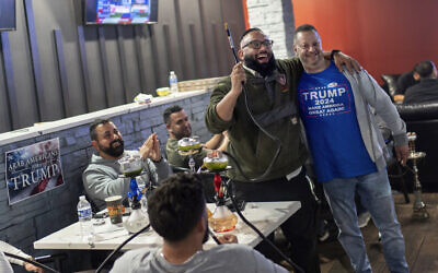 Abrahim Tamimi, left, and Nabeel Hamameh celebrate while watching results come in during an Arab Americans for Trump watch party at the Lava Java Cafe, a hookah lounge, in the early hours of Wednesday, Nov. 6, 2024, in Dearborn, Mich. (AP Photo/David Goldman)