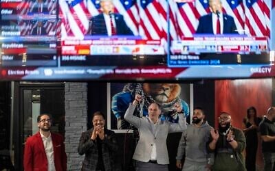 Paul Manni, from left, Sam Alasri, Wasel Yousaf, Waseem Makani and Abrahim Tamimi, cheer as Republican presidential nominee and former US president Donald Trump's speech is broadcast during an Arab Americans for Trump watch party at the Lava Java Cafe, a hookah lounge, in the early hours of  November 6, 2024, in Dearborn, Michigan. (AP Photo/David Goldman)