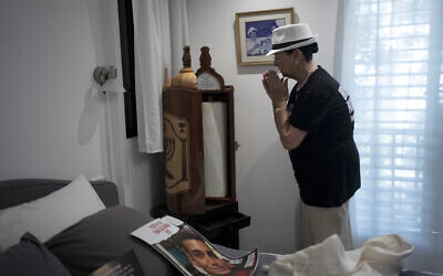 Varda Ben Baruch, whose grandson Edan Alexander is held hostage in the Gaza Strip by Hamas terrorists, gestures to a Torah scroll in his bedroom at home in Tel Aviv, November 14, 2024. (AP Photo/Maya Alleruzzo)