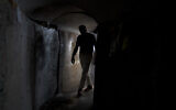 A visitor walks through a replica of a tunnel built by Hamas terrorists in the Gaza Strip, at Hostage Square in Tel Aviv, November 14, 2024. (AP Photo/Maya Alleruzzo)