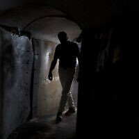 A visitor walks through a replica of a tunnel built by Hamas terrorists in the Gaza Strip, at Hostage Square in Tel Aviv, November 14, 2024. (AP Photo/Maya Alleruzzo)
