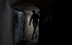 A visitor walks through a replica of a tunnel built by Hamas terrorists in the Gaza Strip, at Hostage Square in Tel Aviv, November 14, 2024. (AP Photo/Maya Alleruzzo)