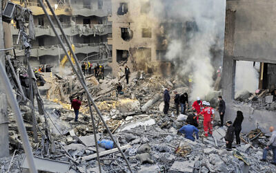 Rescue workers and people search for victims at the site of an airstrike in Beirut, Lebanon, November 23, 2024. (AP Photo/Hassan Ammar)