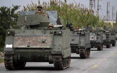 Lebanese Army soldiers ride in a convoy in Mansouri, as they head to southern Lebanon, after a ceasefire between Israel and Hezbollah went into effect on Wednesday, Nov. 27, 2024. (AP Photo/Hussein Malla)
