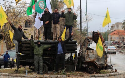 Hezbollah supporters pose near a destroyed rocket launcher following a ceasefire between Israel and Hezbollah that went into effect on Wednesday, Nov. 27, 2024, in Kfar Tebnit, Lebanon. (AP Photo/Mohammed Zaatari)