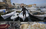 A fisherman jumps from his boat in Tyre, southern Lebanon, November 29, 2024. (AP Photo/Hussein Malla)