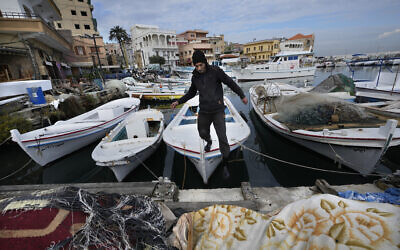 A fisherman jumps from his boat in Tyre, southern Lebanon, November 29, 2024. (AP Photo/Hussein Malla)