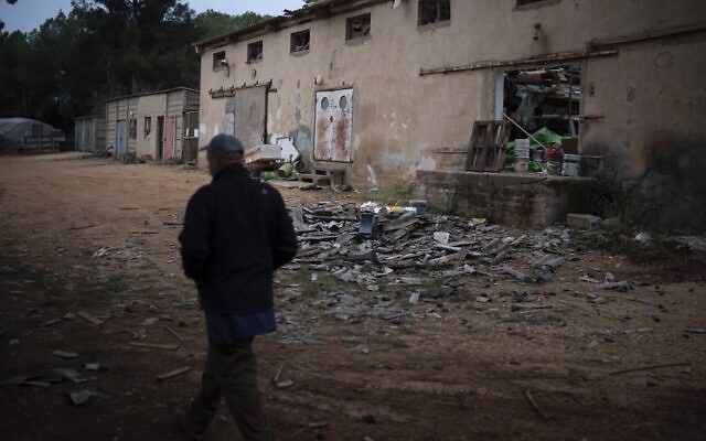 Dean Sweetland walks past a warehouse that was hit by a rocket fired from Lebanon, in Kibbutz Malkiya in northern Israel, November 27, 2024. (AP Photo/Leo Correa)