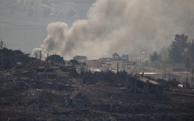 Smoke rises next to damaged buildings on an area of a village in southern Lebanon, as seen from Kibbutz Manara in northern Israel on November 28, 2024. (AP Photo/Leo Correa)