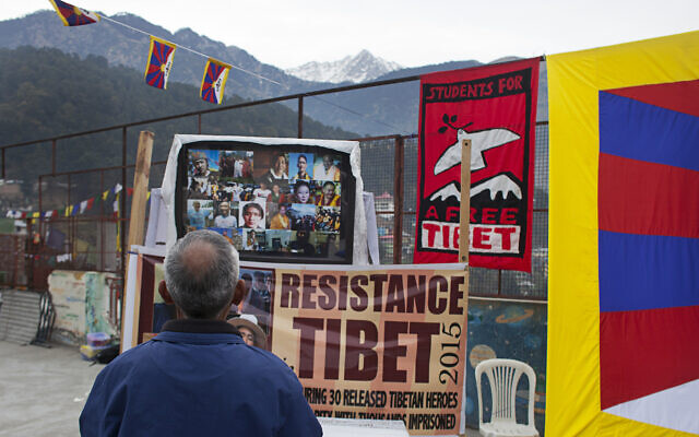 An activist pays his respect in front of portraits of Tibetan political prisoners released in 2015 from Chinese jails during an event organized by Students for a Free Tibet in Dharamshala, India, December 26, 2015. (AP Photo/Ashwini Bhatia)