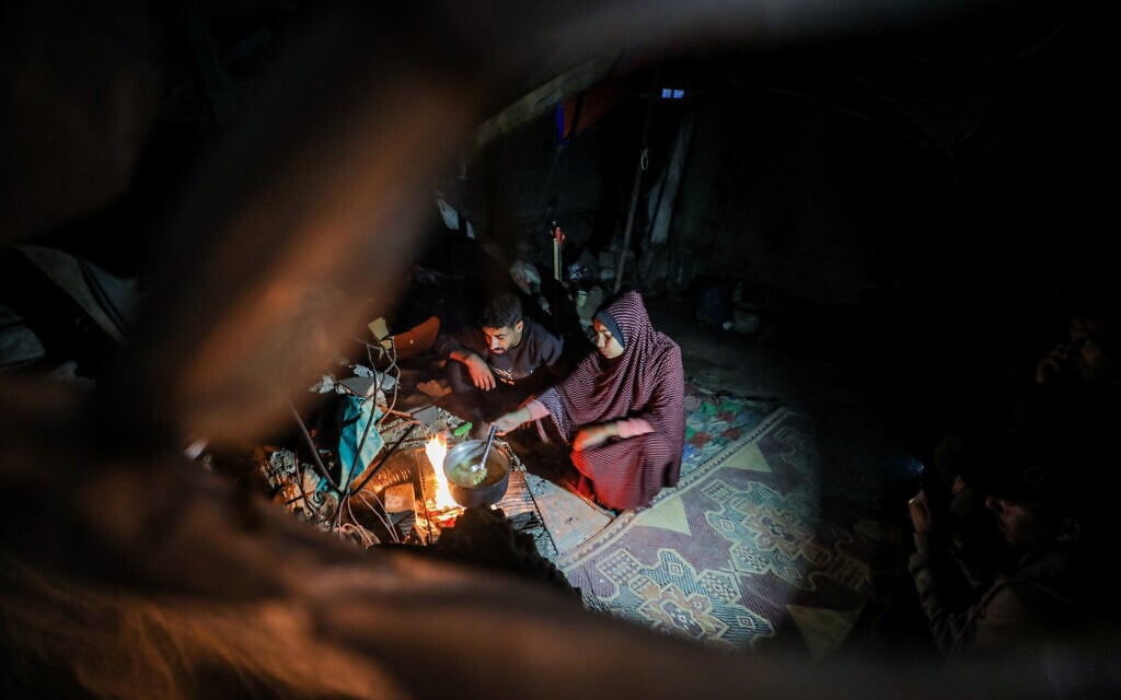 Displaced Palestinians sit near their tent in Nuseirat in the central Gaza Strip, November 14, 2024. (Ali Hassan/Flash90)