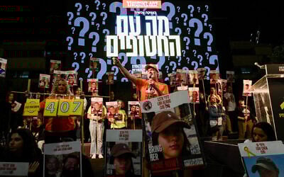 In front of a large screen reading 'What about the hostages?' Jimmy Miller, cousin of hostage Shiri Bibas, leads the crowd in chants of 'Everyone -- now!' during a rally at Tel Aviv's Hostages Square, November 16, 2024. (Avshalom Sassoni/Flash90)