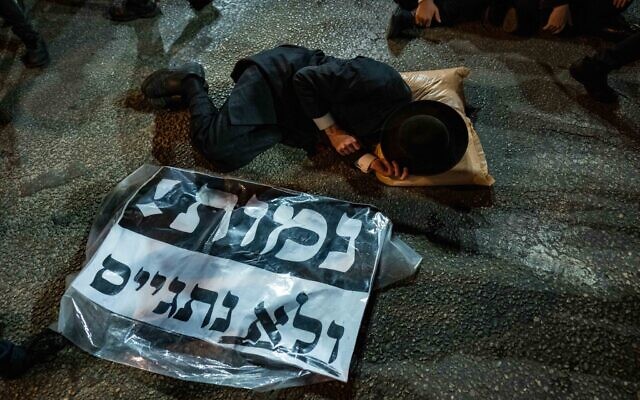 An ultra-Orthodox Jew with a sign saying 'We'd rather die than get drafted,' at a protest in Bnei Brak, November 17, 2024. (Erik Marmor/Flash90) An ultra-Orthodox Jew with a sign saying 'We'd rather die than get drafted,' at a protest in Bnei Brak, November 17, 2024. (Erik Marmor/Flash90)