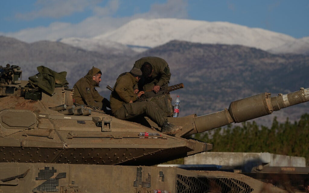 Israeli soldiers in northern Israel near the snow-capped Hermon mountain on November 26, 2024. (Ayal Margolin/Flash90)