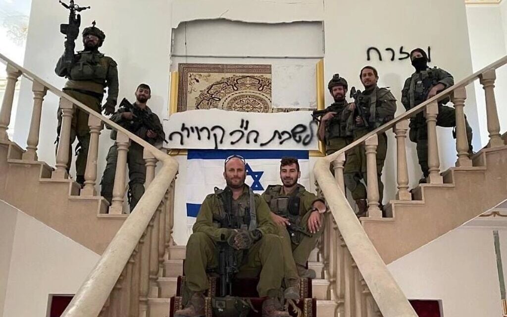 Otzma Yehudit MK Yitzhak Kroizer (center) with fellow soldiers in a house in southern Lebanon on November 1, 2024. The Hebrew graffiti reads: "Office of MK Kroizer." (Courtesy)