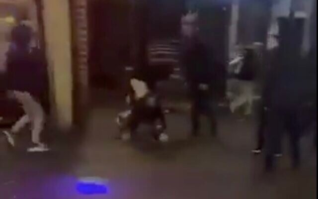 Screenshot from a video showing masked assailants, one of them carrying a Palestinian flag, assaulting a fan of the Maccabi Tel Aviv soccer team in Amsterdam on November 8, 2024. (X screenshot; used in accordance with Clause 27a of the Copyright Law) Screenshot from a video showing masked assailants, one of them carrying a Palestinian flag, assaulting a fan of the Maccabi Tel Aviv soccer team in Amsterdam on November 8, 2024. (X screenshot; used in accordance with Clause 27a of the Copyright Law)