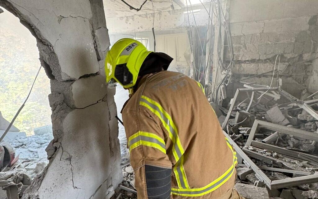 A firefighter in a Kiryat Shmona home destroyed by a direct rocket strike on November 20, 2024. (Courtesy: Fire and Rescue Service North)