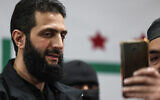Abu Mohammed al-Golani, head of Hayat Tahrir al-Sham (HTS), a jihadist group led by Al-Qaeda's former Syria branch, poses for a selfie during a press conference in the area of Bab al Hawa crossing northern Syria late on March 12, 2024. (Photo by OMAR HAJ KADOUR / AFP)