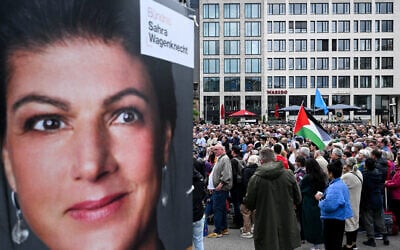 A supporter hoists a Palestinian flag as Sahra Wagenknecht speaks at a campaign rally in Frankfurt, Germany, May 29, 2024. (Photo by Kirill KUDRYAVTSEV / AFP)