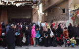 Palestinians wait for food aid outside a distribution center at the Nuseirat refugee camp in the central Gaza Strip on December 4, 2024. (Eyad BABA / AFP)