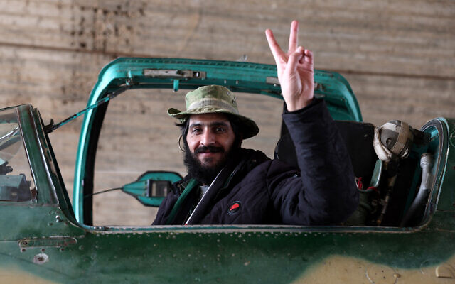 An anti-government fighter gestures as he poses for a picture in the cockpit of a Syrian army jet after rebels took over a military airbase near the central city of Hama, on December 6, 2024. (OMAR HAJ KADOUR / AFP) An anti-government fighter gestures as he poses for a picture in the cockpit of a Syrian army jet after rebels took over a military airbase near the central city of Hama, on December 6, 2024. (OMAR HAJ KADOUR / AFP)