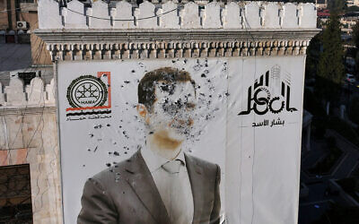 This aerial picture shows a bullet-riddled portrait of Syrian President Bashar al-Assad adorning Hama's municipality building after it was defaced following the capture of the city by anti-government fighters, on December 6, 2024. (Omar Haj Kadour/AFP)
