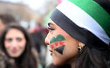 A member of the Syrian community has painted a heart in the colors of Syria on her cheek as she attends a rally on December 8, 2024 in Berlin, Germany, to celebrate the end of Syrian dictator Bashar al-Assad's rule. (Ralf Hirschberger/AFP)