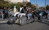 Students drag a toppled statue of late president Hafez al-Assad on the street during a rally near the campus of the Damascus University in the Syrian capital on December 15, 2024. (Omar HAJ KADOUR / AFP)