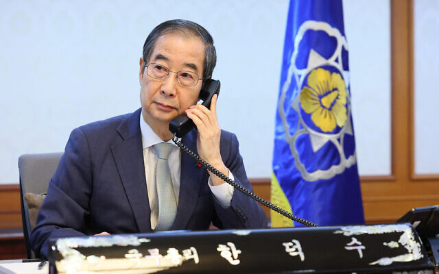 This handout photo taken on December 19, 2024 and released by the South Korean Prime Minister's Office shows South Korea's Prime Minister and acting President Han Duck-soo speaking on the phone to Japanese Prime Minister Shigeru Ishiba at his office in Seoul. (Handout / South Korean Prime Minister's Office / AFP)