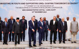 Egypt's President Abdel-Fattah el-Sissi (C-R) gestures to Iranian President Masoud Pezeshkian (5th-R) and Turkish President Recep Tayyip Erdogan (C-L) after a group picture during the D-8 summit in Cairo on December 19, 2024. (IRANIAN PRESIDENCY / AFP)