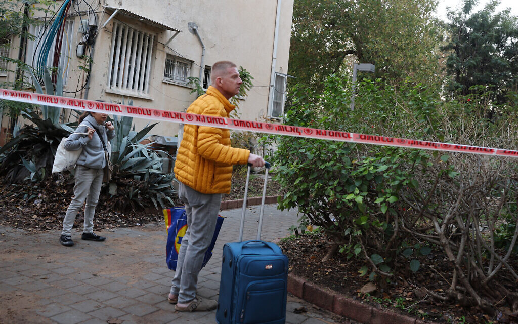 People evacuate their home in Tel Aviv early on December 21, 2024, after a projectile fired from Yemen struck near their building (Jack GUEZ / AFP)